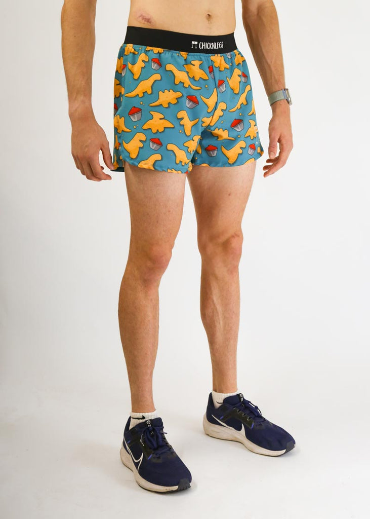 Model wearing chicknlegs men's 4 inch split running shorts in the dino nugget design facing right side view