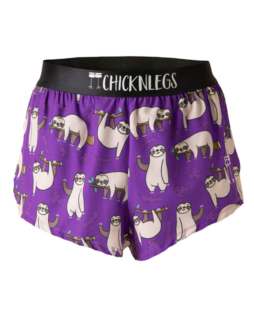 These shorts are from Chicknlegs in the men's 2 in split running shorts in the sloths, as the ghost image. This design has sloths all over them sitting and sleeping, laying on branches and waving. It is on a purple background with leaves.