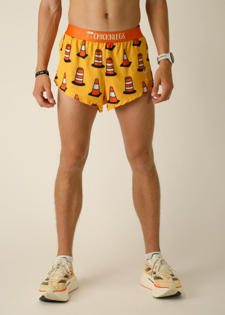 Model wearing Chicknlegs men's 2 inch split running shorts in the traffic cones design, facing front.