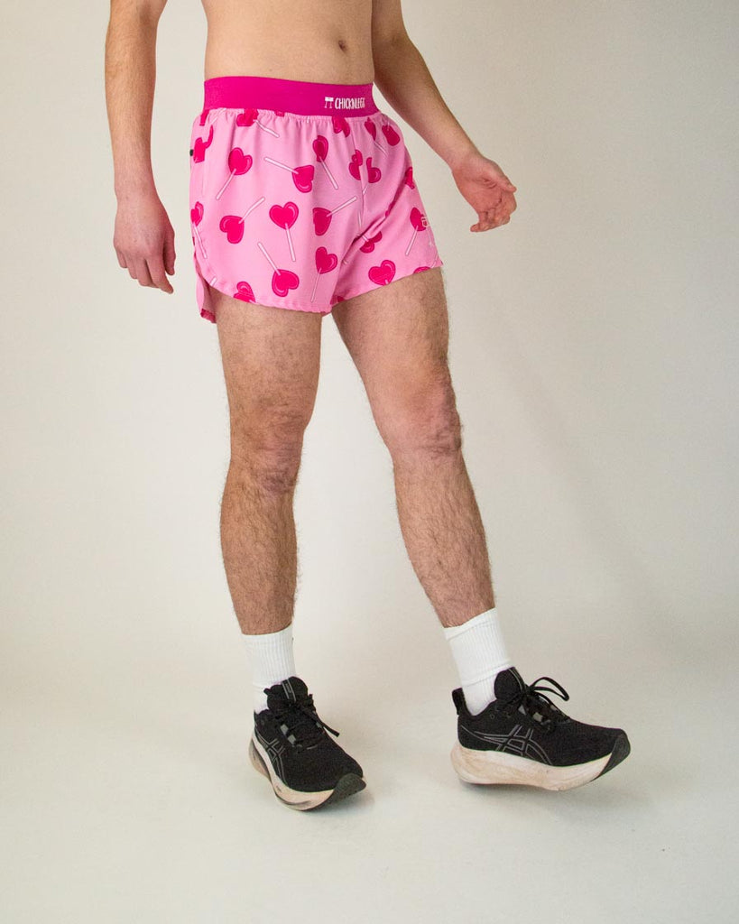 The model is a runner who is wearing Chicknlegs in the men's 4" in split running shorts in the LuvPops design, facing right to show the side view.