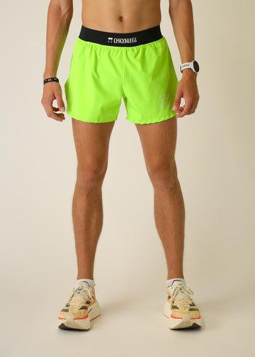 Model wearing Chicknlegs men's 4 inch split running shorts in the neon green design, facing front.