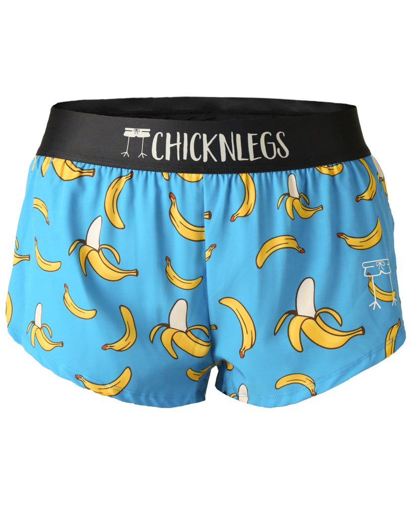 These shorts are from Chicknlegs as the women's 1.5 in split running shorts in the blue banana design, as a ghost image. The print has fun bananas in yellow all over it on a blue background.