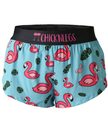 These shorts are from Chicknlegs in the women's 1.5 in split running shorts in the blue flamingo design, as a ghost image. The print has pink flamingos on it with green leaves and a blue background.