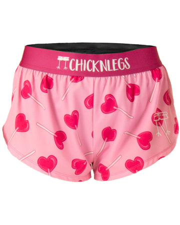 These are from Chicknlegs in the women's 1.5 in split running shorts in the LuvPop design, as a ghost image. The print has pink heart lolipops on it on a pink background.