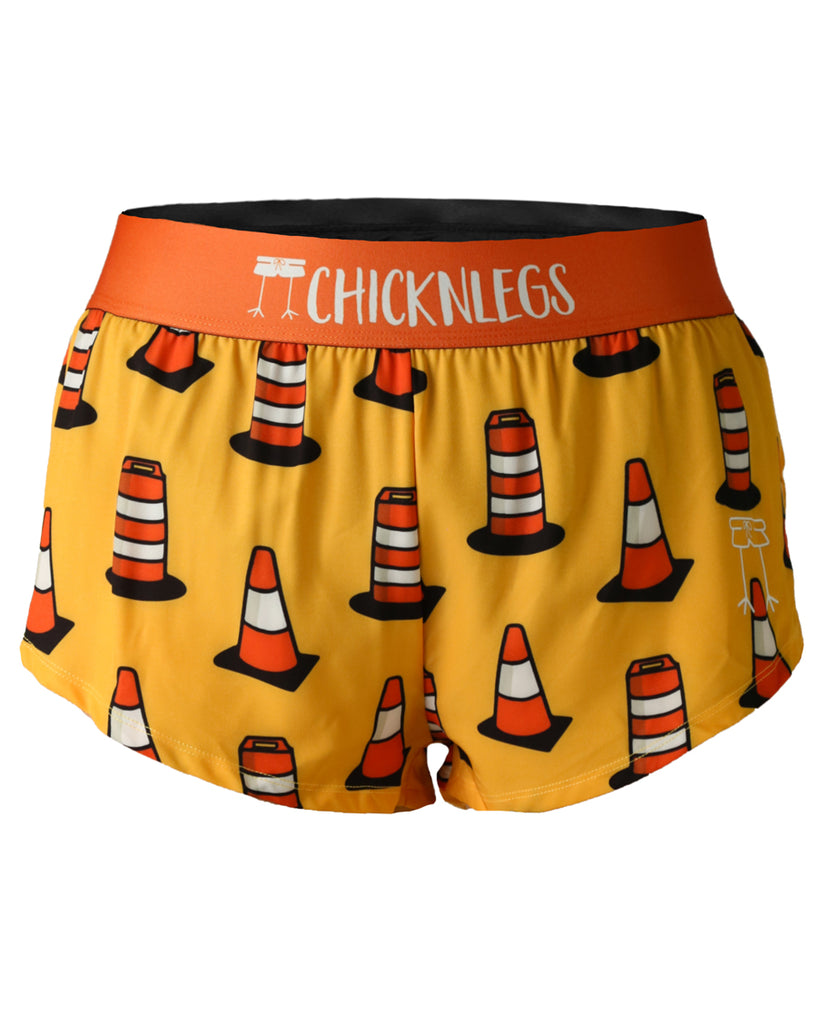 Chicknlegs women's 1.5 in split running shorts in the traffic cones design, as a ghost image. The print has fun various traffic cones all over it with a light orange yellow background.