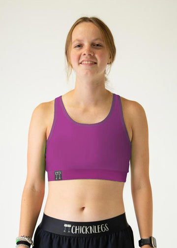 The model is a runner who is wearing Chicknlegs women's og sports bra in the deep purple design, facing front. A close up is shown.