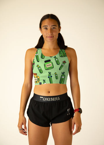 The model is a runner who is wearing Chicknlegs women's pwr crop top in the pickles design, facing front.