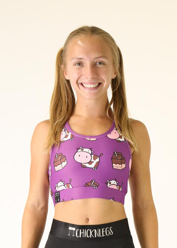 Model wearing Chicknlegs OG Sports Bra in the choccy cows design facing front in a close up shot shown.