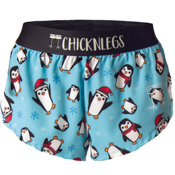 A ghost image is shown of Chicknlegs women's 1.5" split running shorts in the Slippery Bois, penguins design.