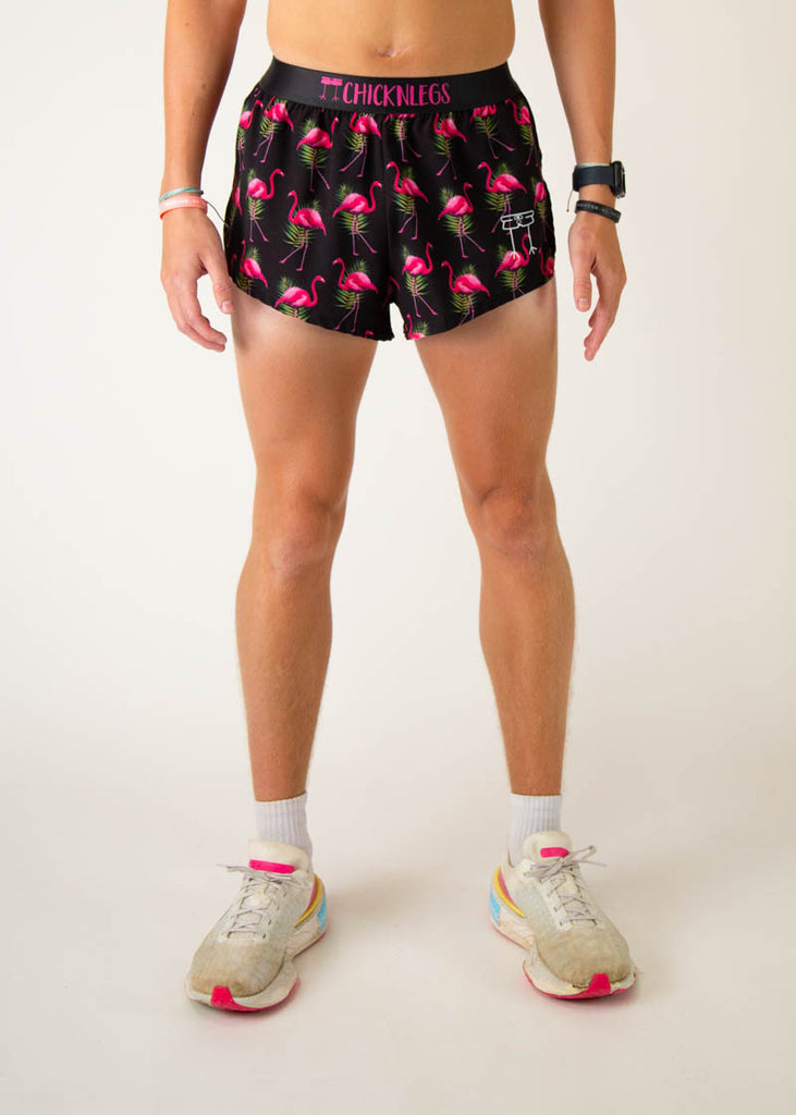 Model is a runner wearing Chicknlegs men's 2 inch split running shorts in the black flamingo design, facing front.
