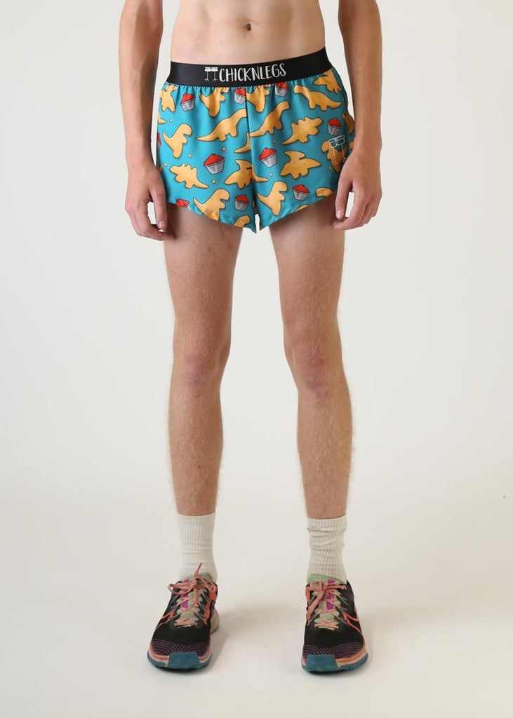 Model wearing Chicknlegs mens 2 inch split running shorts in dino nugget design front view