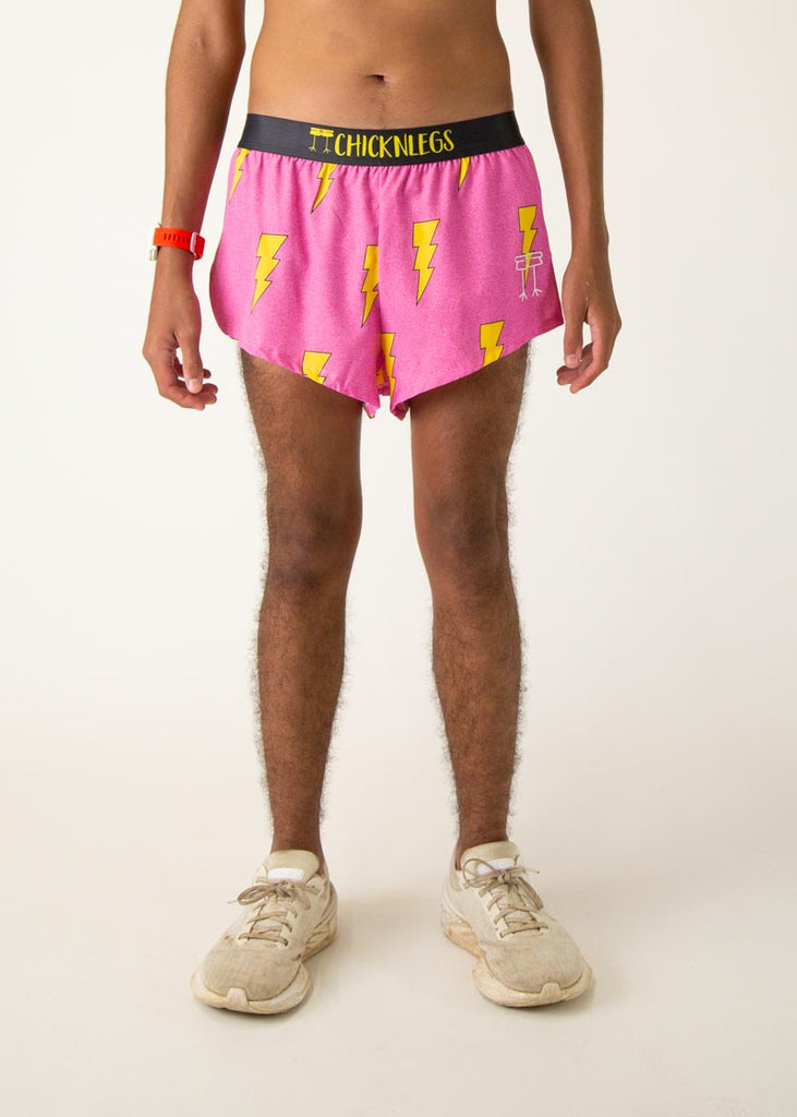 The model is a runner who is wearing Chicknlegs men's 2 inch split running shorts in the pink bolts design, facing front.