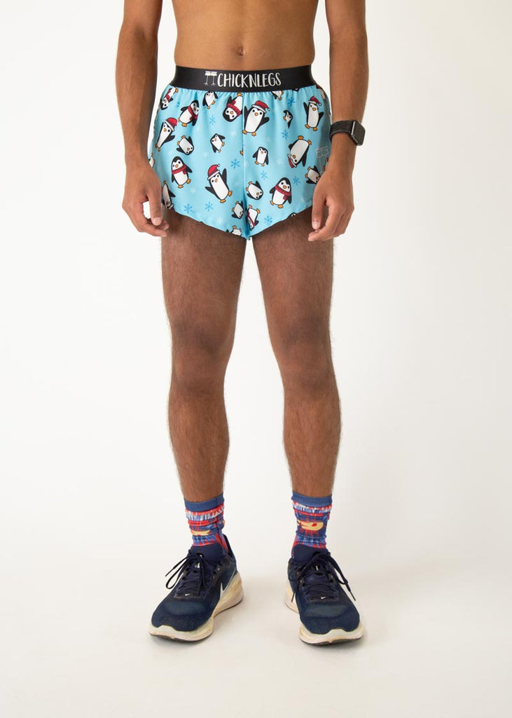 The model is a runner who is wearing Chicknlegs men's 2 inch split running shorts in the Slippery Bois, Penguins design, facing front.