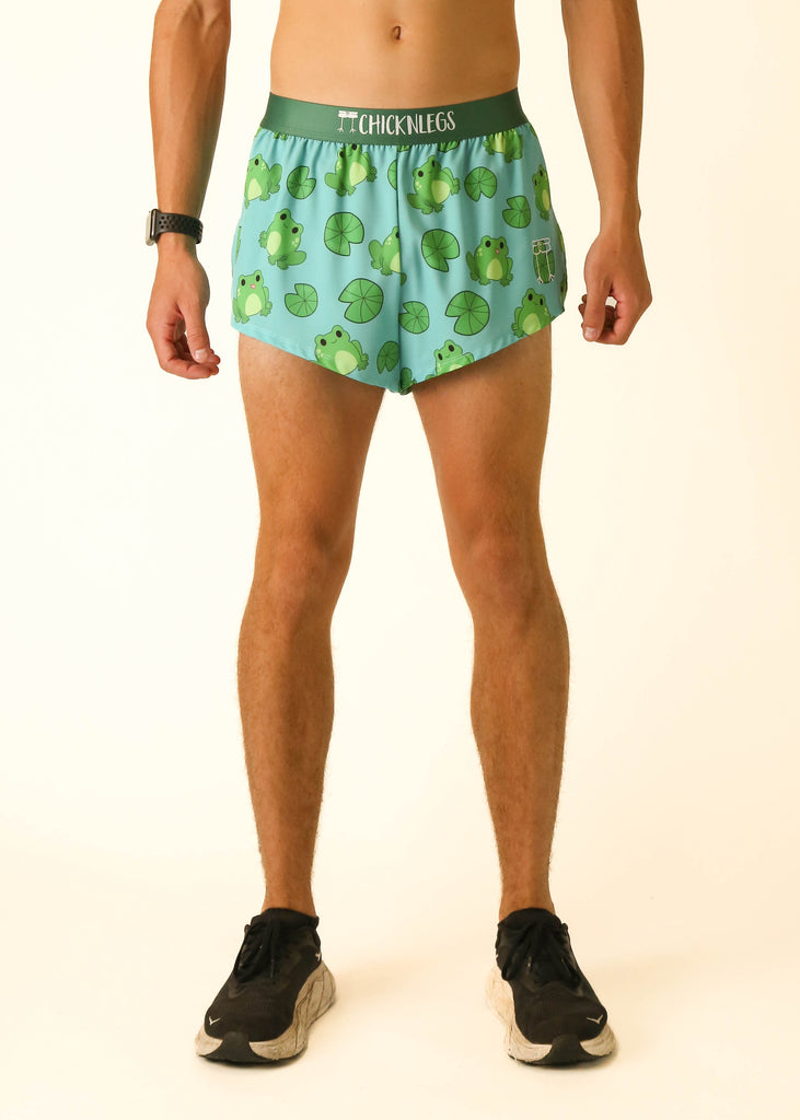 Model is a runner wearing athletic shorts made by  Chicknlegs in the men's 2 inch split running shorts in the Fartlek Froggies Frog design, facing front.
