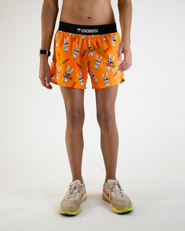 Runner is wearing ChicknLegs in the men's 4 in split running shorts in the bad bunny design, facing front. The print has white rabbits on it with sunglasses and carrots on an orange background.