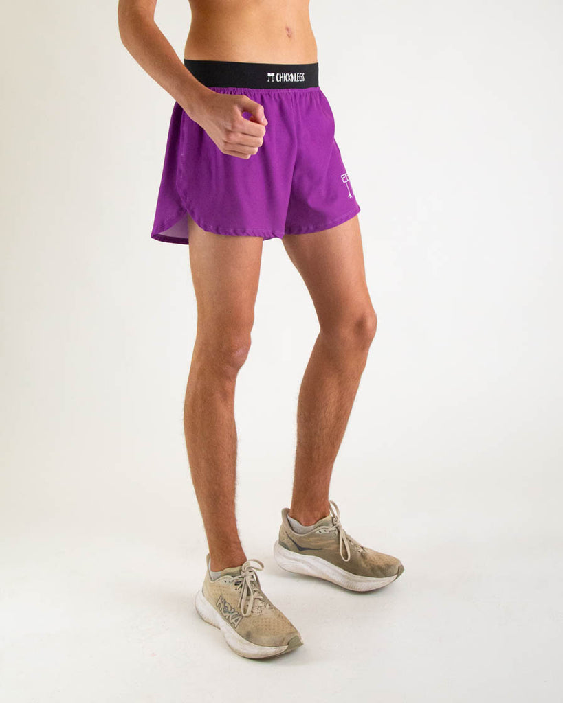 Runner is wearing ChicknLegs in the men's 4 in split running shorts with a back zipper pocket in the deep purple color facing right, great for matching fits with the choccy cow design.