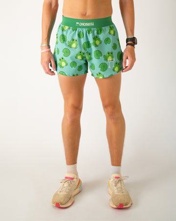 Runner is wearing ChicknLegs in the men's 4 in split running shorts with a back pocket and an inner liner pocket. The print has frogs on it with lilypads. The froggies are green on a light blue background.