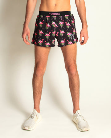 Runner is wearing ChicknLegs in the flamingo design in the men's 4 in split running shorts that has a back pocket and inner liner pocket. The design has pink flamingos on it with green leaves and a black background.