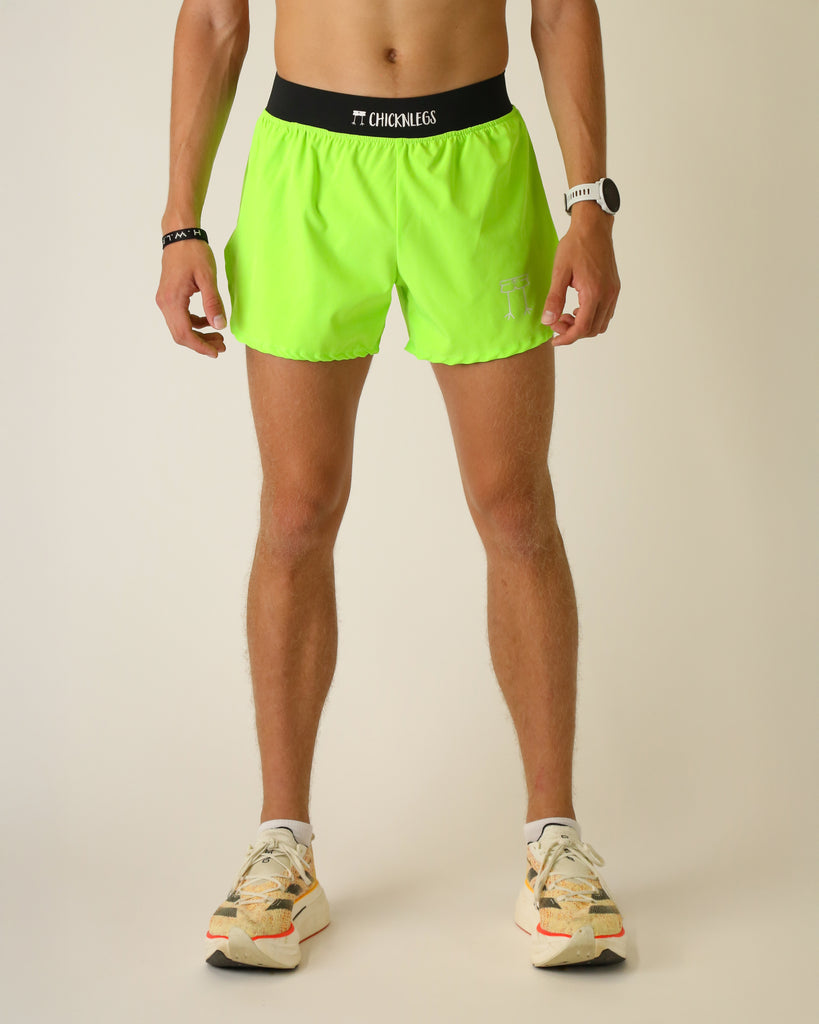 Runner is wearing ChicknLegs in the men's 4 in split running shorts with a back pocket and inner liner pocket. The print is solid neon green.