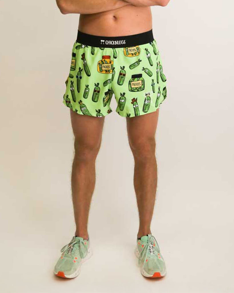 Runner is wearing ChicknLegs in the men's 4 in split running shorts with a back pocket and inner liner pocket. The print has pickles all over it in fun various shapes , the jars are green and yellow.