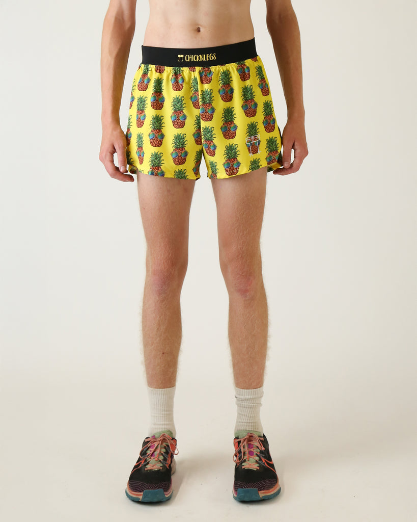 Runner is wearing ChicknLegs in the men's 4 in split running shorts with a back pocket and inner liner pocket. The print is pineapples with sunglasses on it with yellow background.