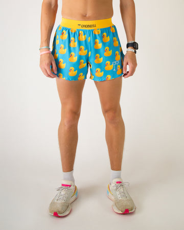 Runner is wearing ChicknLegs in the men's 4 in split running shorts with a back pocket and inner liner pocket. The print has rubber duckys on it that are bright yellow on a blue background.