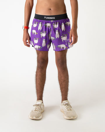 Runner is wearing ChicknLegs in the men's 4 in split running shorts with a back pocket and inner liner pocket. The print has a a lot of sloths on it who are waving, standing and laying down on branches. The background has leaves on it with a purple background.