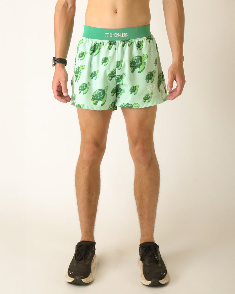 Runner is wearing ChicknLegs in men's 4 in split running shorts with a back pocket and inner liner pocket. The print has sea turtles over it that are green on a light green background.