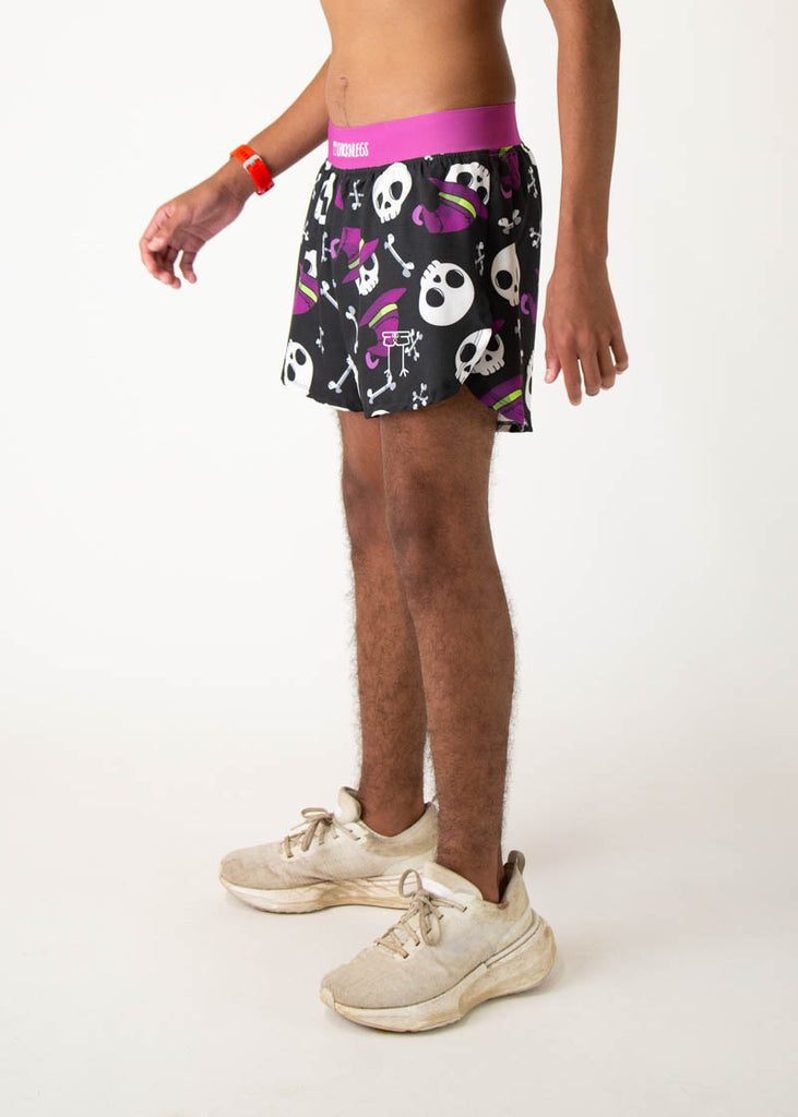 The model is a runner who is wearing Chicknlegs running shorts in the men's 4 inch split runners shorts in the skulls design, facing left.