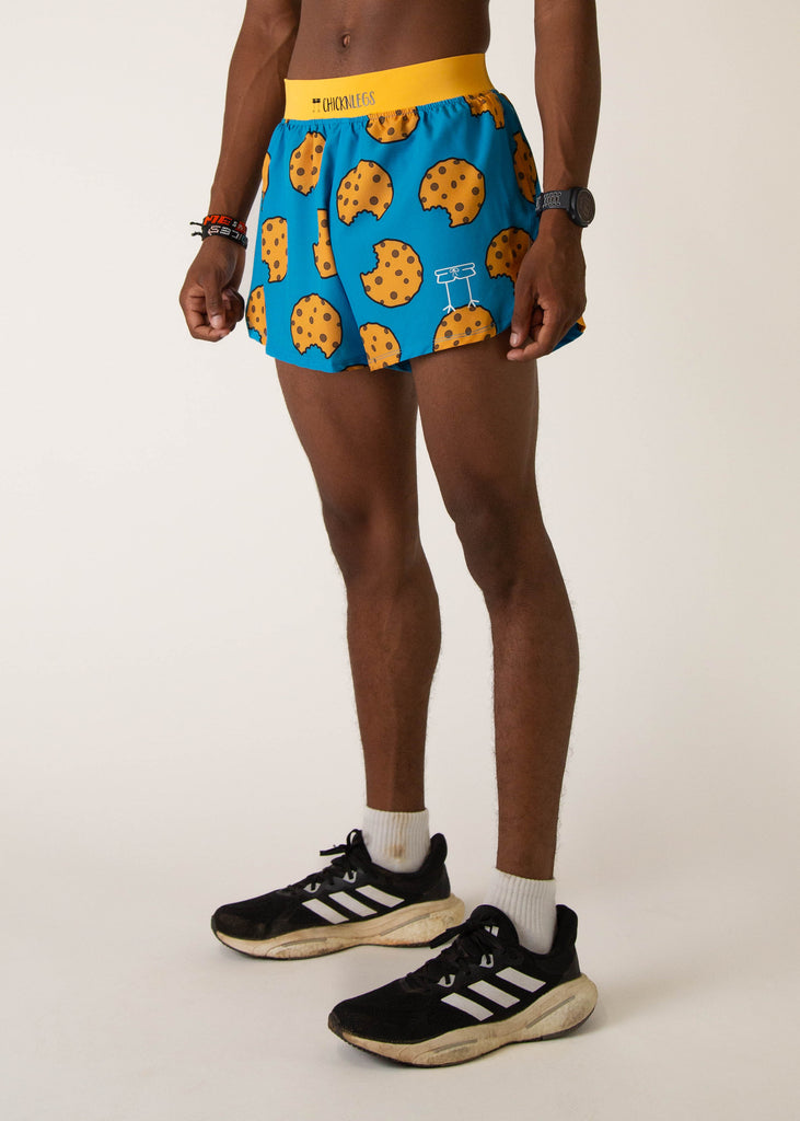 Model wearing Chicknlegs in mens 4 inch split running shorts in the cookies design, facing left.
