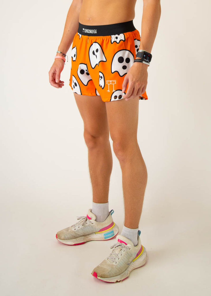 The model is a runner wearing Chicknlegs men's 4 inch split running shorts in the Ghost design, facing left.
