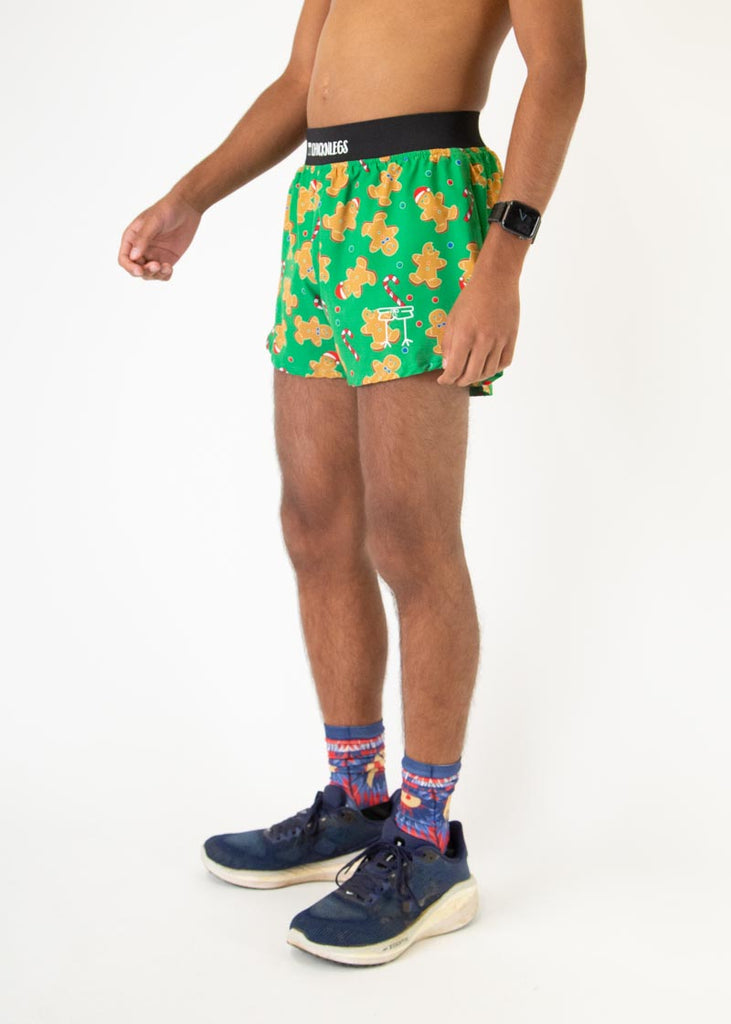 The model is a runner who is wearing Chicknlegs in men's 4 inch split running shorts in the Gingerbread Men's Gingy's Revenge design, facing left.