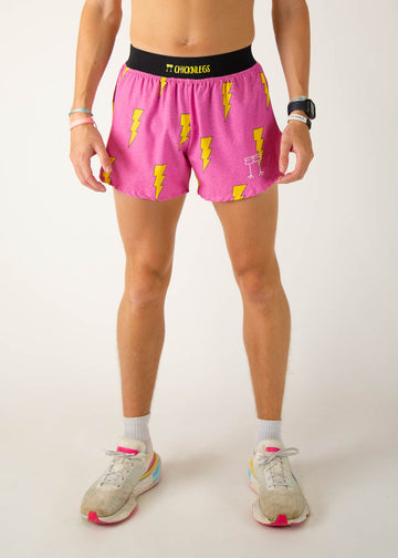 The model is a runner wearing Chicknlegs men's 4 inch split running shorts in the hot pink bolts design, facing front.
