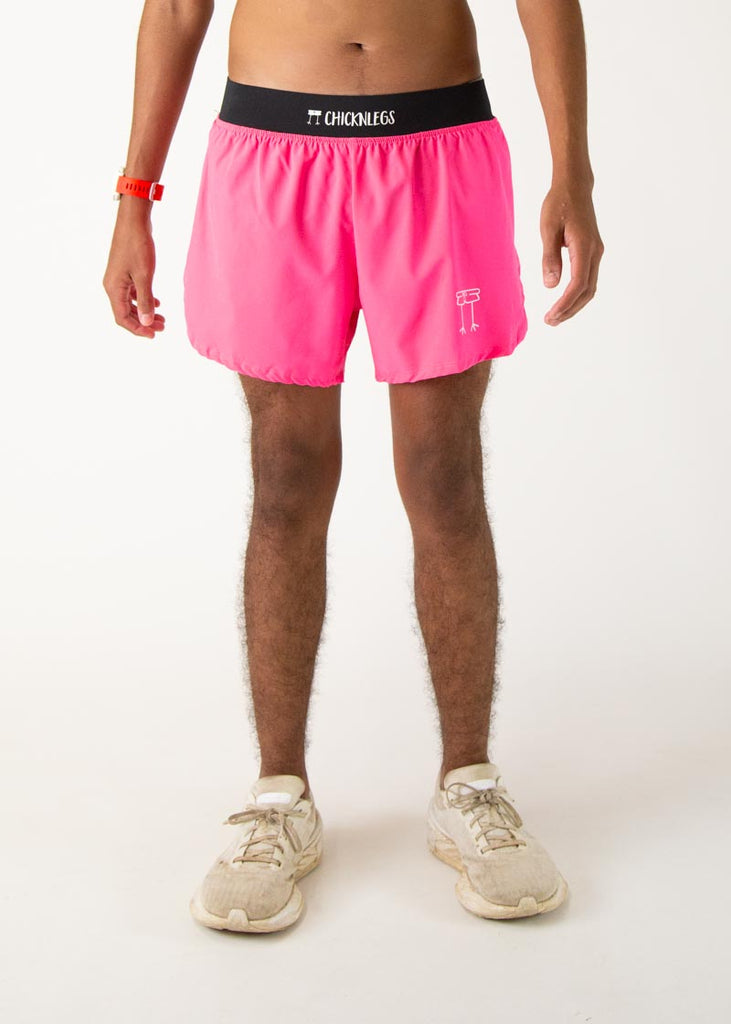 The model is a runner who is wearing Chicknlegs men's 4 inch split running shorts in the neon pink design, facing front.