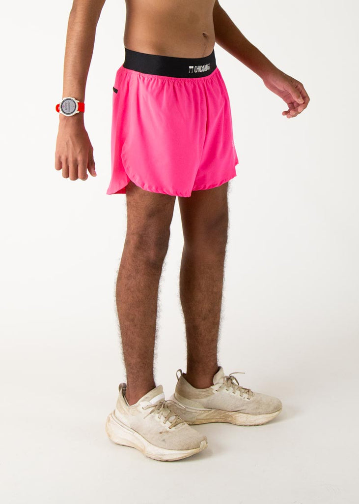 The model is a runner who is wearing Chicknlegs men's 4 inch split running shorts in the neon pink design, facing right,