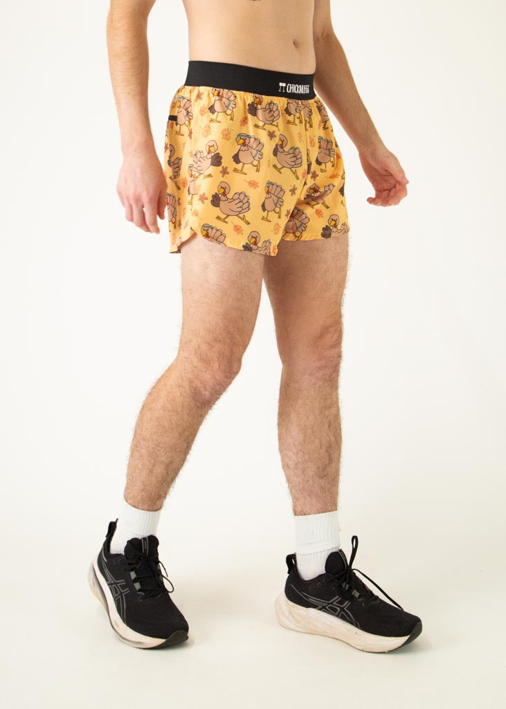 The model is a runner who is wearing Chicknlegs men's 4 inch split running shorts in the pardoned turkey design, facing right.