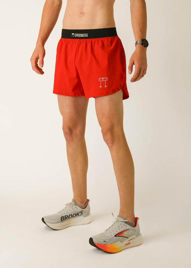 Model is wearing Chicknlegs men's 4 inch split running shorts in the red design, facing left.