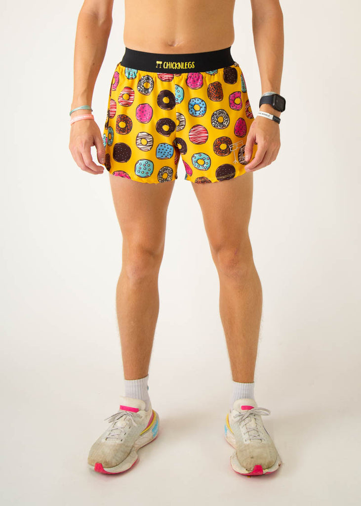 The model is a runner wearing Chicknlegs in the men's 4 inch split running shorts in the salty donuts design, facing front.
