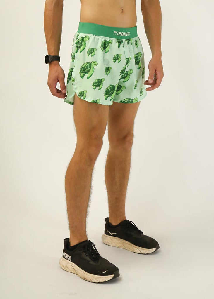 Model is a runner who is wearing Chicknlegs men's 4 inch split running shorts in the turtles design, facing right.