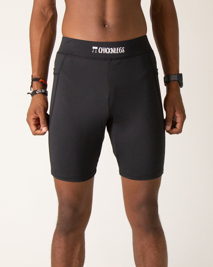 Runner is wearing ChicknLegs in the men's 8 in half tights with pockets in the black design. The print has the solid black color.