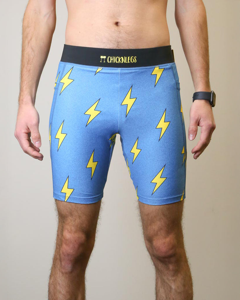 Runner is wearing ChicknLegs in the men's 8 in half tights with pockets in the blue bolts design. The print has yellow lightning bolts on a solid blue background.