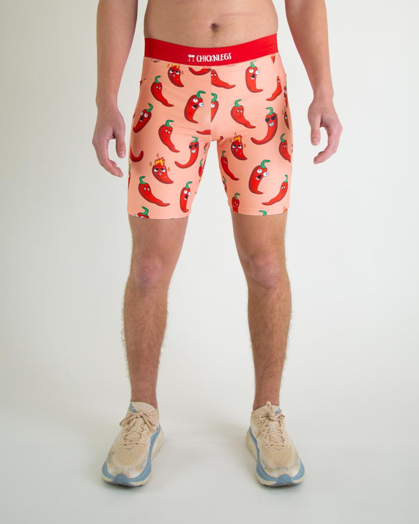 Runner is wearing ChicknLegs in the men's 8 in half tights in the red hot chili pepper design. The print has red, green and orange on it for front view.