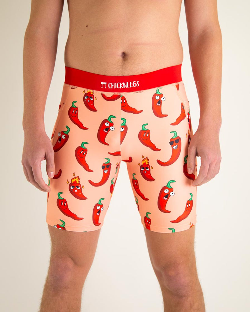 Runner is wearing ChicknLegs in the men's 8 in half tights with pockets in the chili pepper design. The print has fun bright red peppers all over it.