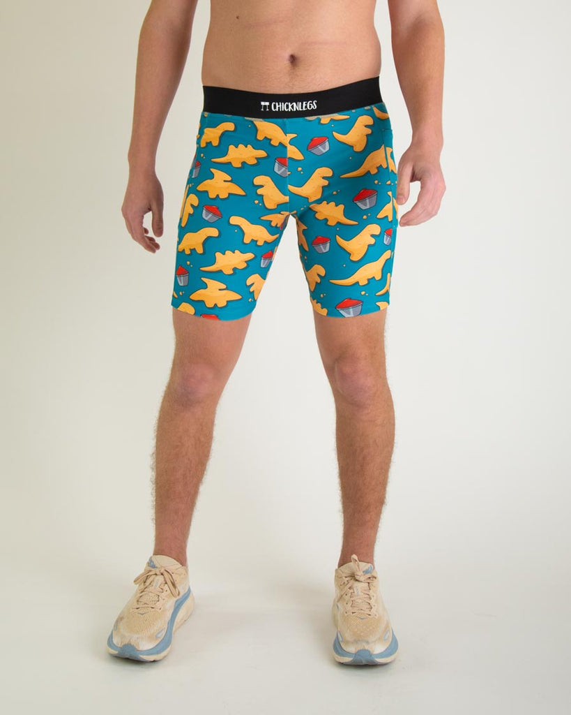 Runner is wearing ChicknLegs in the men's 8 in half tights with pockets in the dino nugget design. The print has chicken dinosaur nuggets on it with ketchup in an orange, red and blue color. A front view of the halftights are shown, great for long distance running and performance to prevent chaffing.  