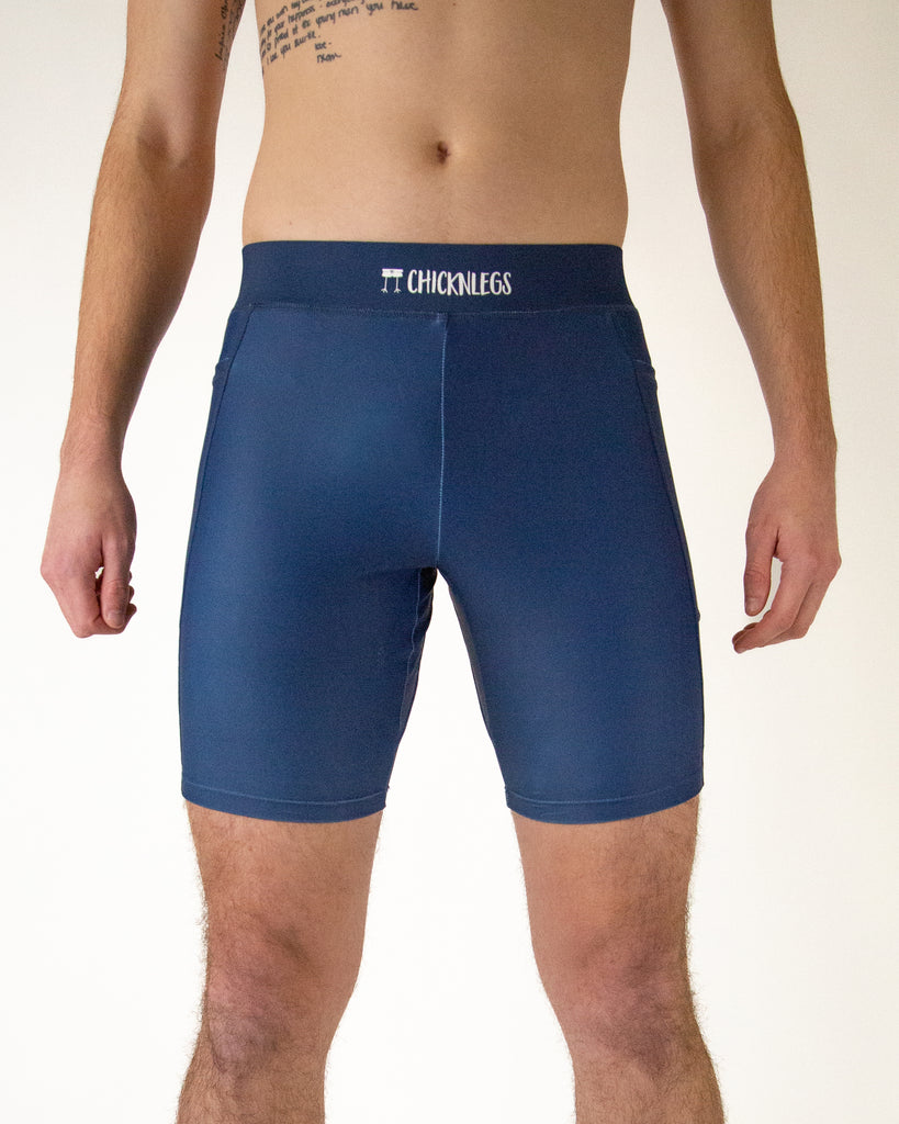 Runner is wearing ChicknLegs in the men's 8 in half tights with pockets in the navy design. The print is the solid navy color.