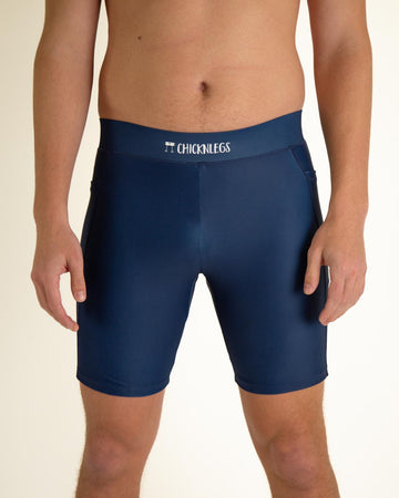 Runner is wearing ChicknLegs in the men's 8 in half tights with pockets in the navy design. The print is a solid navy blue color as a close up image.