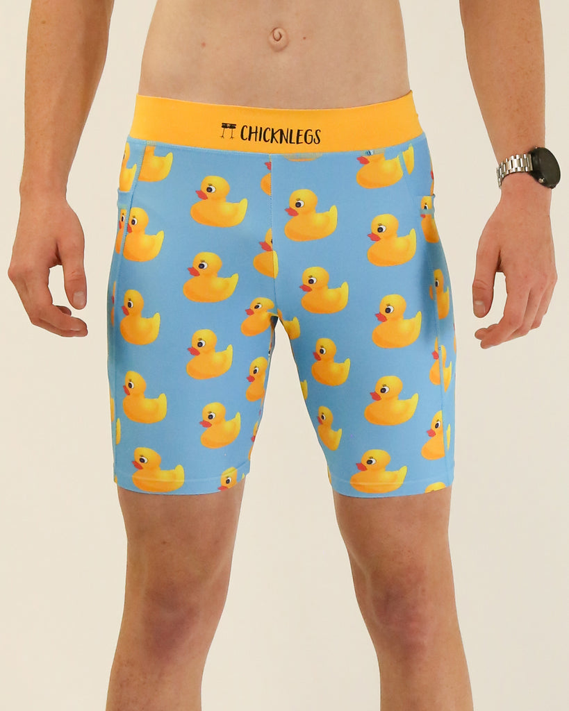 Runner is wearing ChicknLegs in the men's 8 in half tights with pockets in the rubber duckys design. The print has fun yellow rubber ducks on it with a solid blue background.