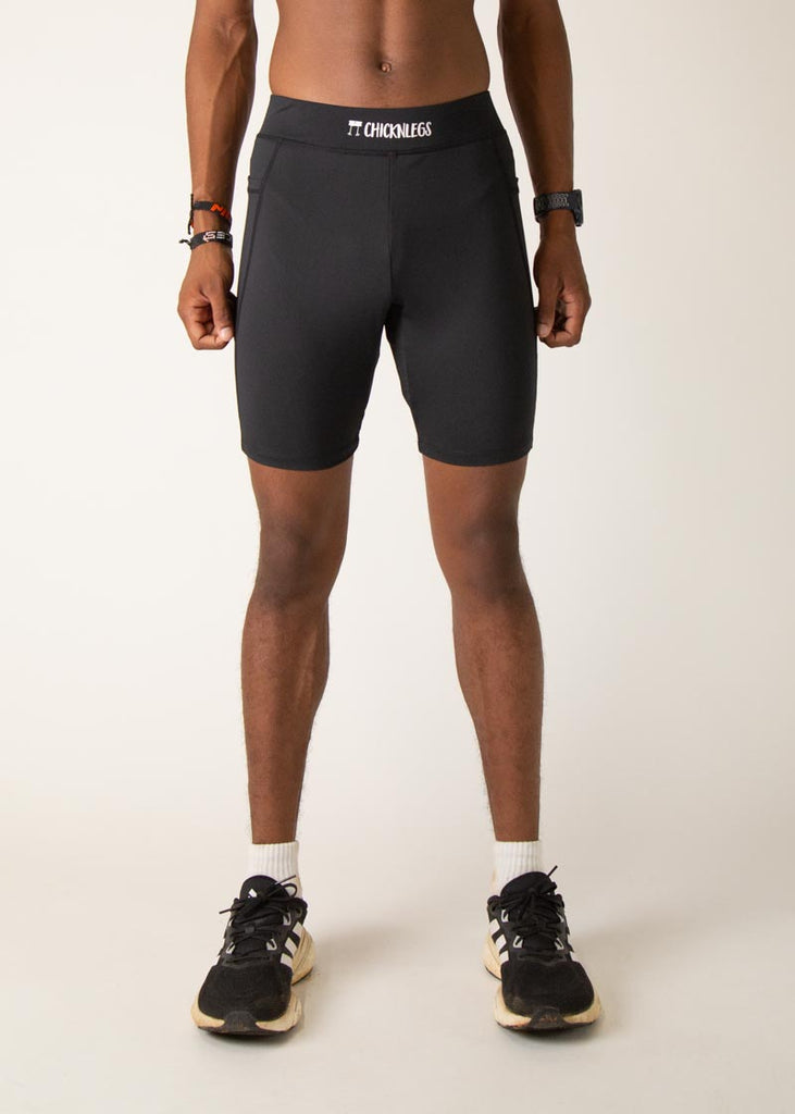 Model wearing Chicknlegs men's 8 inch half tights in the black design, facing front. 