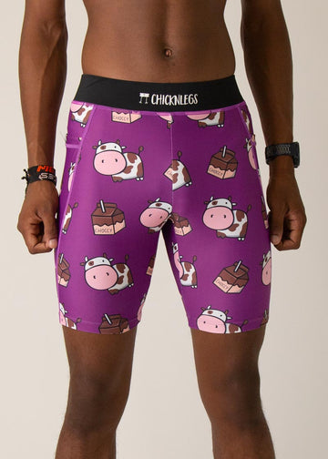 Model wearing Chicknlegs men's 8 inch half tights in the choccy cow design, facing front.  A close up shot is shown of the half tights in this photo.