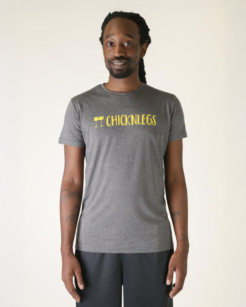 Runner is wearing ChicknLegs in the men's graphic tee shirt in the heather grey gray color with yellow text on it across the chest that says chicken legs.